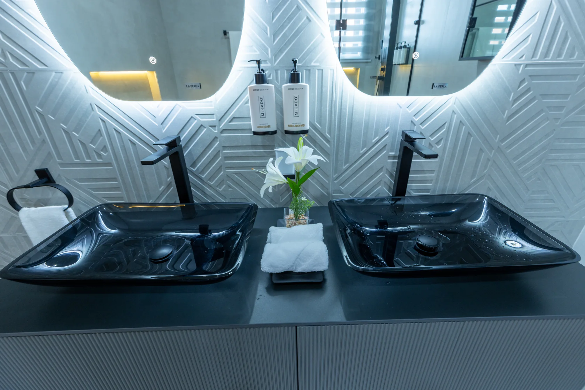 Double vanity with sculptural basins and textured wall