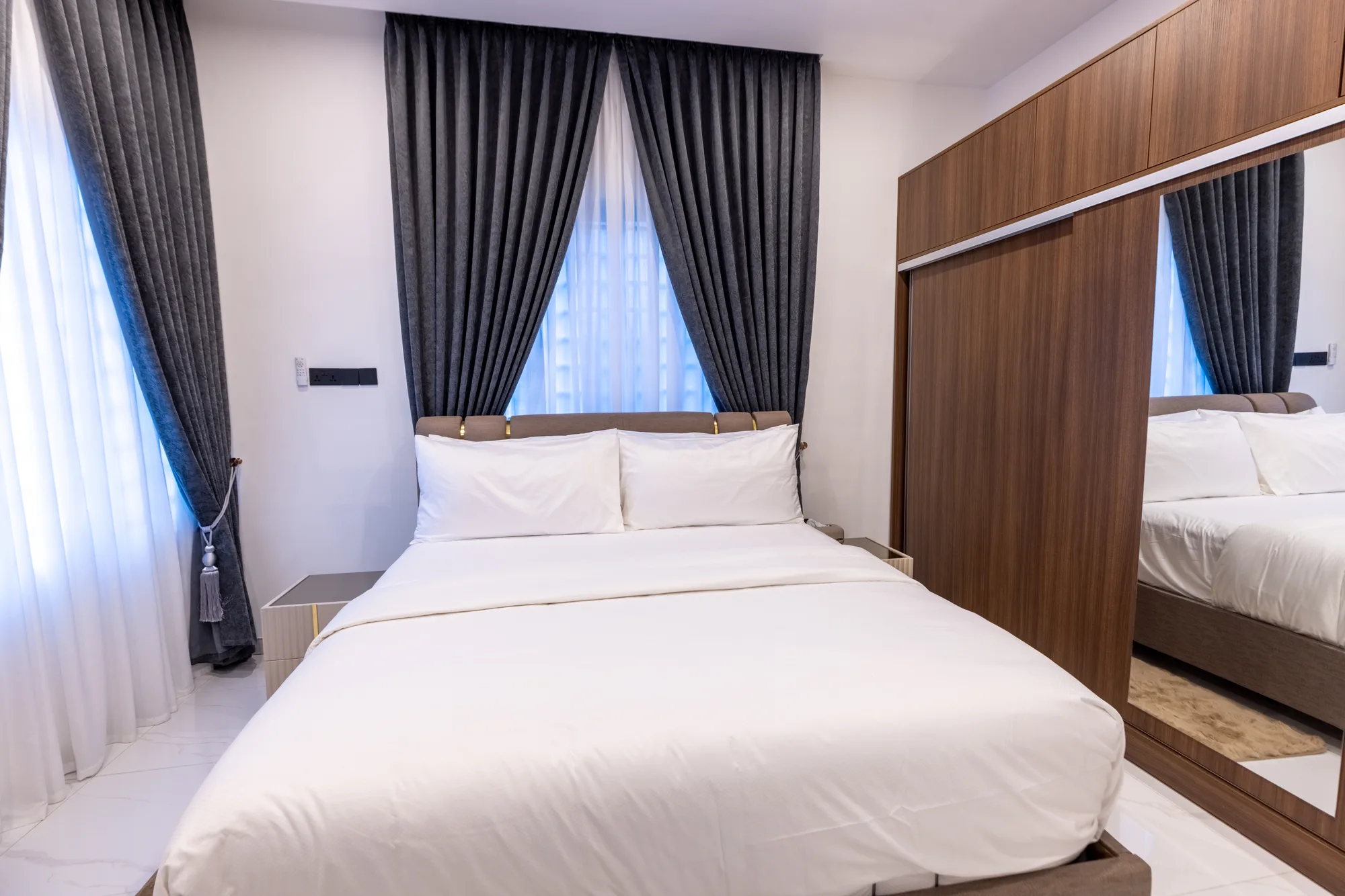 Bedroom with mirrored wardrobe and neutral bedding